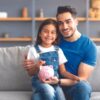 dad daughter with a piggy bank