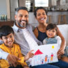 Proud,Parents,Showing,Family,Painting,Of,Son,And,Daughter,Sitting