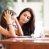 Mother,Helping,Stressed,Teenage,Daughter,Looking,At,Laptop