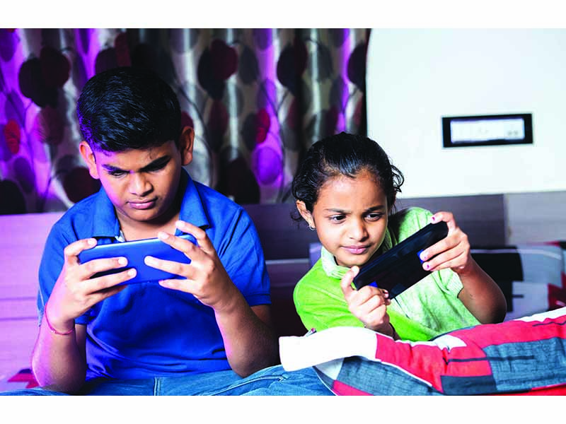 Siblings,Busy,Playing,Video,Game,On,Mobile,Phone,During,Night