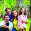 Portrait,Of,Happy,Young,Indian,Family,Sitting,On,Lush,Green
