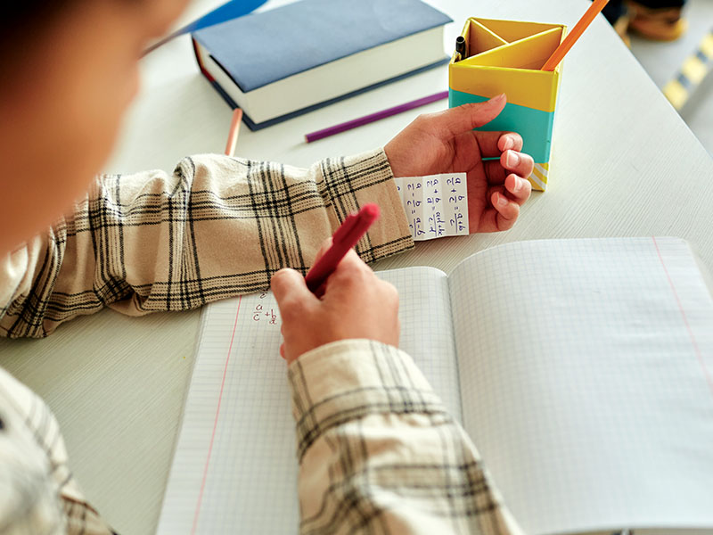 Close,Up,Of,Unrecognizable,Young,Boy,Cheating,During,Test,In