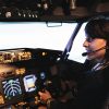 Aircrew member flying plane from cockpit with dashboard command