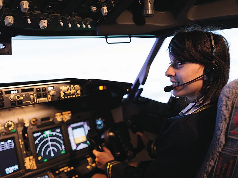 Aircrew member flying plane from cockpit with dashboard command