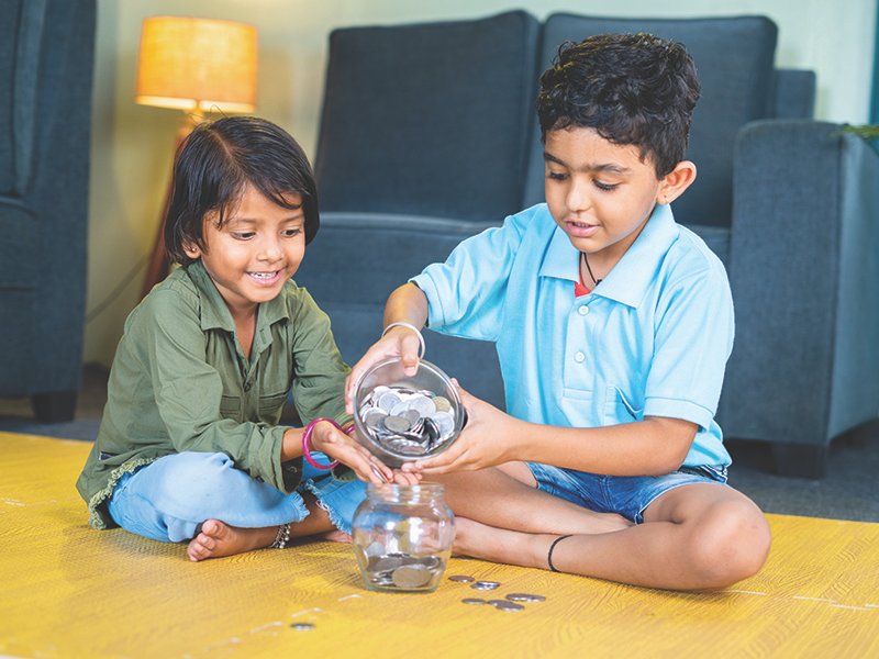 Young,Sibling,Kids,Putting,Coin,On,Glass,While,Sitting,On
